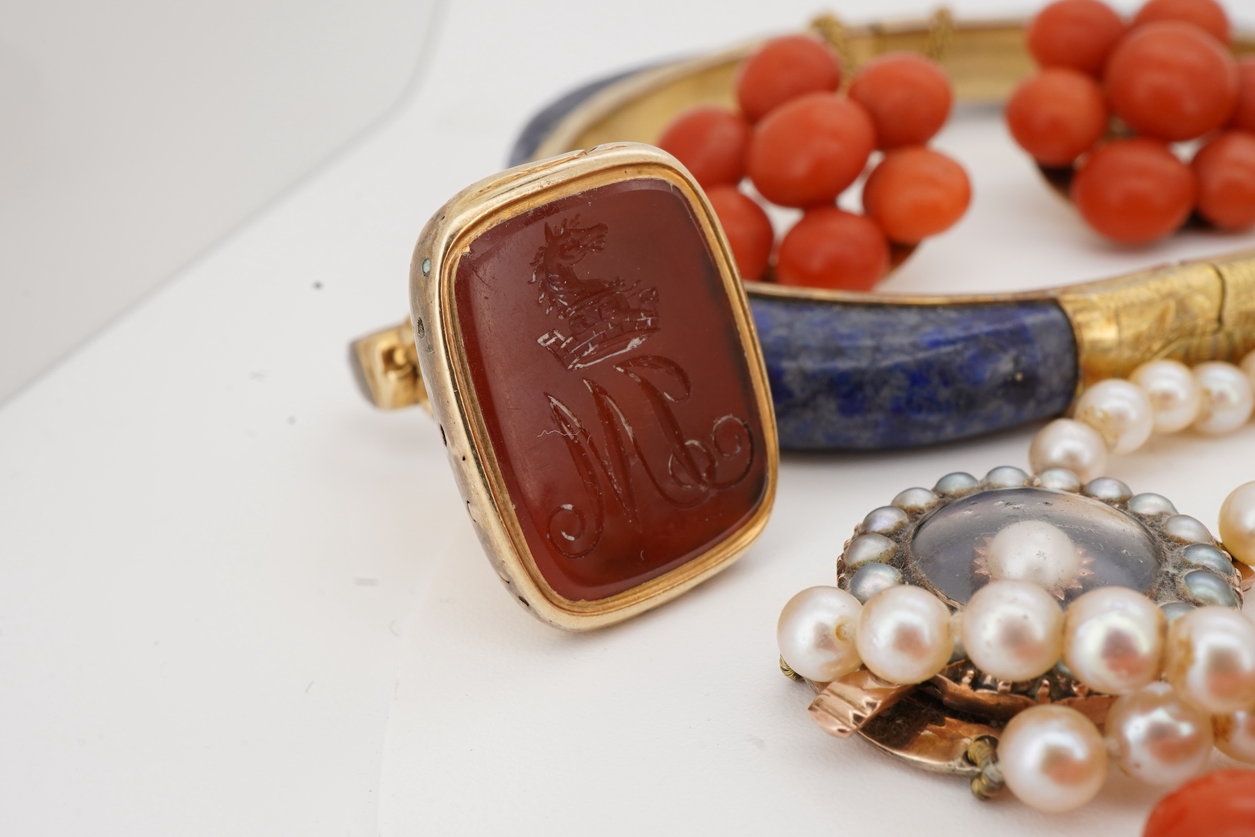 A collection of jewels including a coral demi-parure, comprising: a coral necklace and pair of earrings, lengths 46 and 2.5cm respectively, necklace clasp stamped 14K, earrings with post fittings; a carnelian fob seal wi